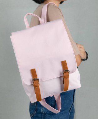 Uzun kollu kahverengi gömlekli ve kot pantolonlu bir kadın modelin, beyaz arka planda büyük, beyaz, çok amaçlı bir çanta asılı halde yakın plan çekimleri..