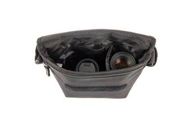 Küçük fotoğrafçı yakın çekim stüdyosu modern moda gri şok geçirmez bel çantası yumuşak bel çantası dijital DSR kamera len ve akıllı telefonu beyaz arka planda taşıyor..