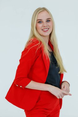 Kırmızı elbiseli hoş sarışın kadının kapalı alanda çekilmiş portresi beyaz arka planda izole edilmiş neşeli ve olumlu duygularla reklam jestinde kameraya poz veriyor..