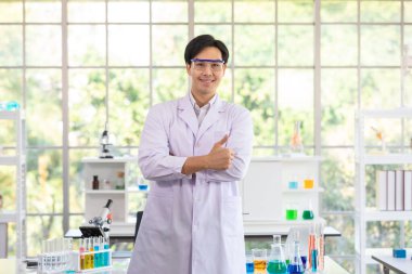 Resim, Portredir. Laboratuvar ya da hastanede araştırma yapmak için beyaz önlük giyen Asyalı bilim adamı ya da araştırmacı. Tıbbi kimya araştırması kavramı