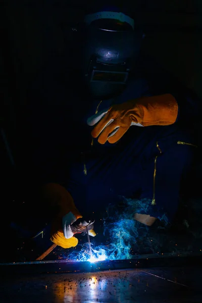 焊机把钢焊接在一起 使其更加坚固 工作产生明亮的火花有烟 效果形成光加上烟使它看起来美丽的蓝光 弧度是一门需要技巧的专业 — 图库照片