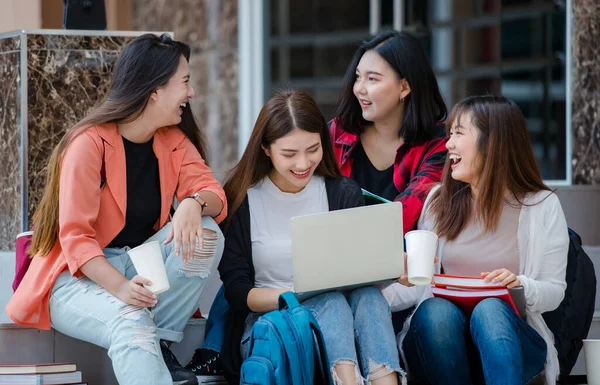 Group of four young attractive asian girls college students studying together in university campus outdoor. Concept for education, friendship and college students life.