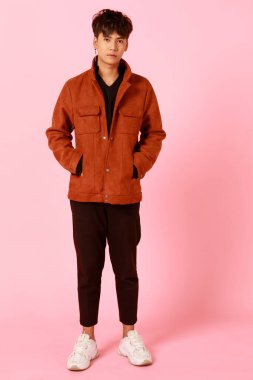 Kırmızı ceketli genç ve hippi görünümlü Asyalı bir adamın portresi arkadaş canlısı ve kendinden emin görünüyor..