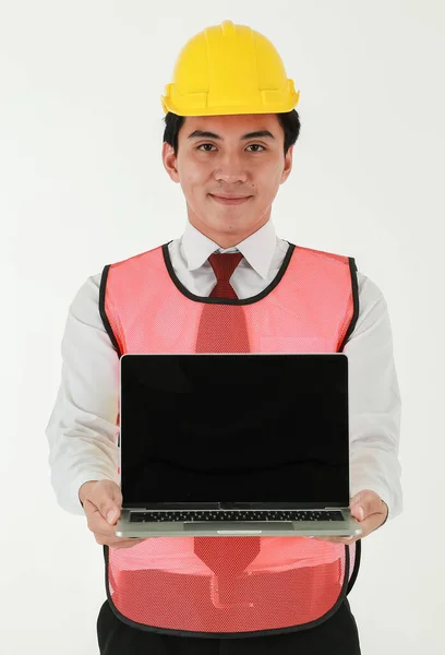 白いシャツに輝くアジアのエンジニア 黄色のヘルメットと安全ベストを身に着けている赤いネクタイメッセージのためのコピースペースと空白の画面を提示ノートパソコンを保持 — ストック写真