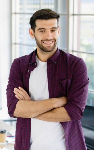 İş adamı ayakta ve kollarını kavuşturuyor.