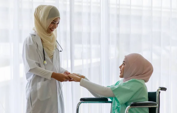 若い女性のイスラム教徒の医師が話し 病院で車椅子に座って若い病気のイスラム教徒の患者を応援 — ストック写真