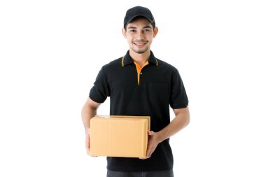 Neşeli Asyalı teslimatçı paketi iki elinde tutuyor, kameraya gülümsüyor. İzole edilmiş beyaz arka planda siyah üniformalı kurye portresi. E-ticaret iş konsepti