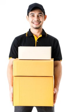 Mutlu Asyalı kurye, karton kutuları el arabasının yanında tutuyor. İzole edilmiş beyaz arka planda, siyah üniformalı teslimatçının tam boy dikey portresi. E-ticaret iş konsepti
