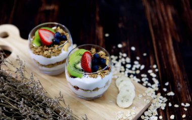 Meyve ve kraker keserek iki bardak sağlıklı beyaz tatlı çok tatlı görünüyor. Ahşap masada nefis süslemeler ve nefis yemekler.