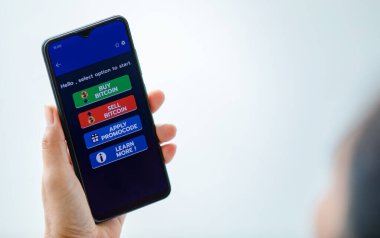 Elele tutuşup akıllı telefon ekranını şifreli döviz alım satım ve tanıtım kodlarıyla fotokopi alanı ile şifreli işlem uygulamalarıyla göstererek.