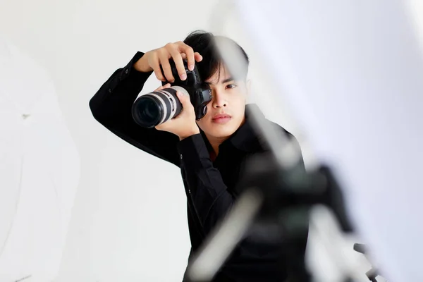 Asyalı Yakışıklı Erkek Fotoğrafçı Günlük Siyah Gömlek Giyiyor Kamerayı Tutuyor — Stok fotoğraf