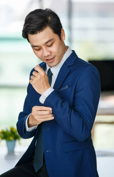 Wesoły Młody Przystojny Azjatycki Biznesmen Dostosowując Rękawy Stojąc Szczęśliwym Pozytywnym — Zdjęcie stockowe