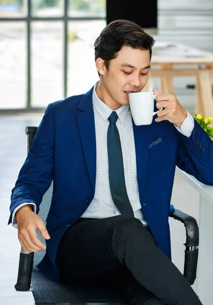 Азійська Юна Людина Синьому Костюмі Сидить Офісі Тримає Чашку Кави — стокове фото