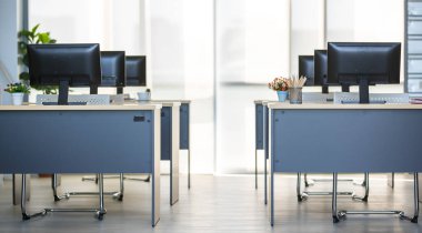 Modern iç mekan, ofis ya da işyerinin arka plan fotoğrafı ve ahşap masalar üzerinde sıralı bilgisayarlar. Teknoloji ve İş Konsepti