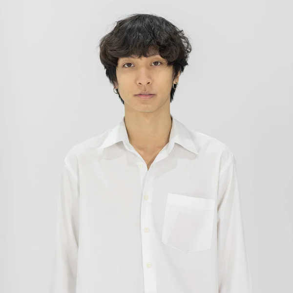 머리가 곱슬곱슬 셔츠를 자신감을 가지고 카메라를 쳐다보며 아시아의 청년의 — 스톡 사진
