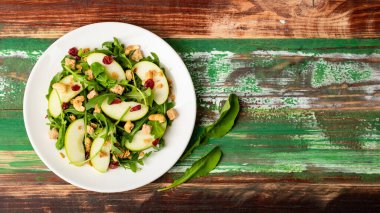 Taze yeşil elma dilimi salatası, roket yaprağı, yulaf tanecikleri, kurutulmuş kızılcık, ve kaju fıstığı....