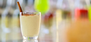 Lezzetli kremalı ev yapımı yumurta likörü, bardakta zencefilli ekmek, Şükran Günü Noel arifesi partisinde içki masasında diğer alkollü içki şişeleri ve abur cuburlarla çevrili..