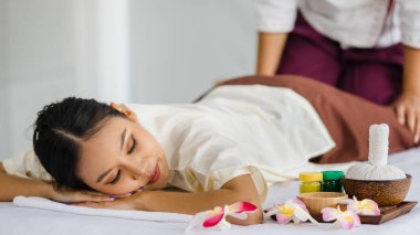 Güzel Taylandlı bir kadın spada mutlu bir şekilde masaj yaptırmaktan hoşlanıyor. Tayland masajıyla rahatlatıcı ve iyileştirici. Vücut bakımı ve tedavisi, alternatif tıp konsepti.