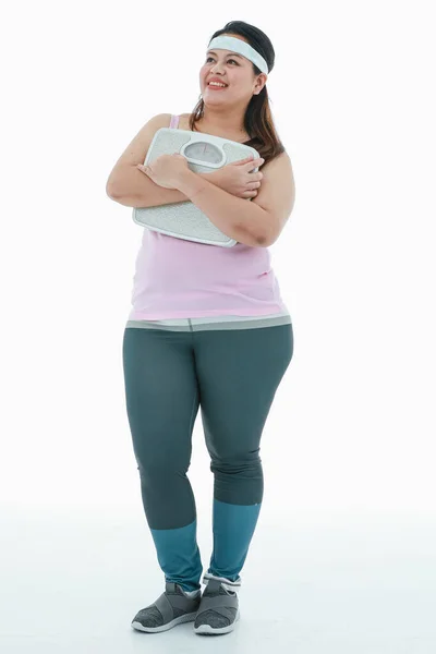 亚洲快乐 胖胖的女孩穿着粉色运动服 头戴头巾站着笑的照片 运动结束后 举着体重增加的体重增加在白种人面前 — 图库照片