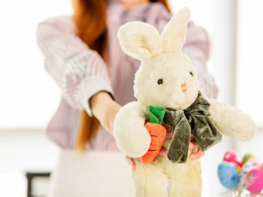 Sevgiyle güzel tavşan bebeği tutan bir kadının elleri.