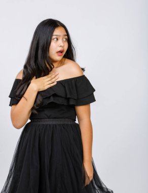 Güzel bir genç kızın dikey portresi. Beyaz arka planda izole edilmiş, göğsüne doğru kaldırarak resmin yan tarafına bakıyor. İnanılmaz terfi kavramı