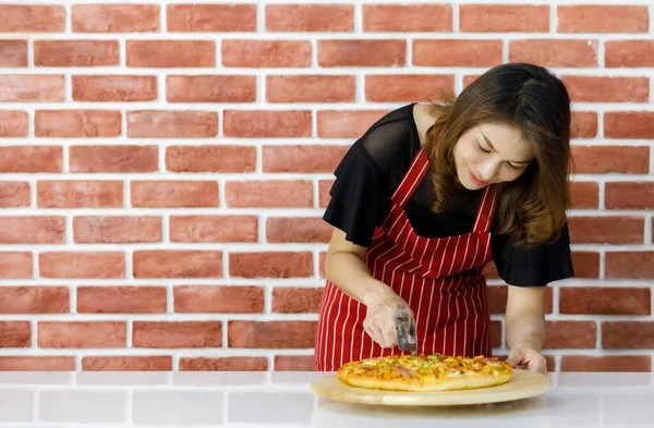 줄무늬 앞치마를 아시아 주부가 미소를 머금고 가까이에 맛있는 요리된 피자를 — 스톡 사진
