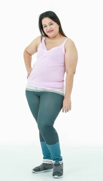 亚洲快乐健康强壮胖胖的胖胖的女孩穿着运动服腿裤子站在镜头前微笑着在白色背景上摆出一副放松的姿势 — 图库照片
