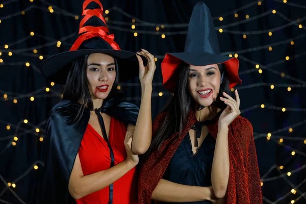 Очаровательные Молодые Девушки Плащах Ведьм Шляпах Красными Губами Смотрящие Камеру — стоковое фото