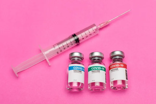 Medical syringe with needle and 3 sealed glass capsule of covid-19 vaccine prepared to activate volunteer immunity against coronavirus infection to prevent outbreak