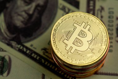 Üzerinde kripto döviz işareti ve dolar banknotunun üzerinde sembol olan bir yığın altın sikke. Engelleme zinciri için fikir, iş dünyasının ekonomisinde yeni tip para.