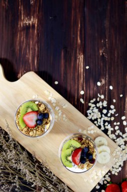 Meyve ve kraker keserek iki bardak sağlıklı beyaz tatlı çok tatlı görünüyor. Ahşap masada nefis süslemeler ve nefis yemekler.