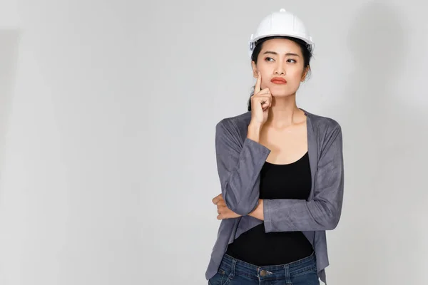 Pensive Asijské Žena Dodavatel Hardhat Stojící Šedém Pozadí Dotýkající Hlavy — Stock fotografie