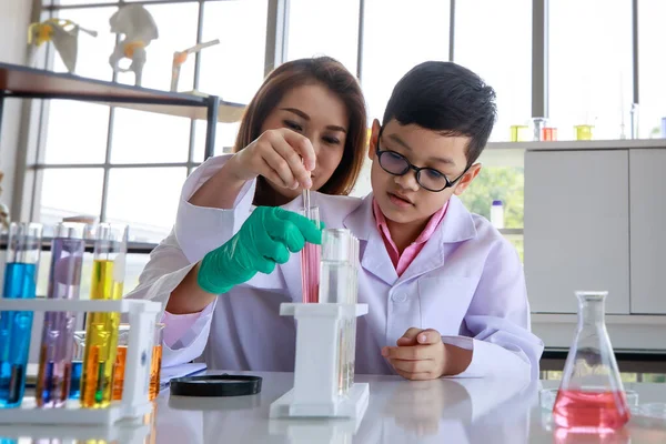 초점을 아시아 의학생 실험실에서 수업을 교사의 도움을 실험을 하면서 액체를 — 스톡 사진