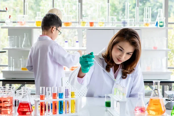 アジアの大学生が実験室で科学研究中にカラフルな液体で実験を行う — ストック写真