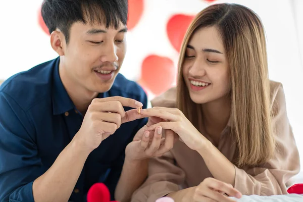 聖バレンタインの日に喜んでくれる女性の指に婚約指輪をはめながら笑顔の幸せなアジア人男性 十代の恋人の概念の公開愛と関係 — ストック写真