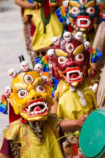 Oidentifierade munkar med trummor utför en religiös maskerade och scenkostymer mysterium dans av tibetanska buddhismen under Cham dansfestival i Hemis kloster — Stockfoto