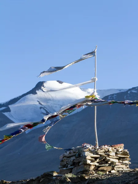 Stupa und buddhistische Gebetsfahnen im Wind gegen Berge und blauen Himmel — Stockfoto