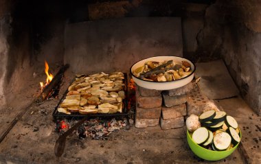 Rustic dinner in the Rhodope mountains - roasting on coals on the grill in the oven just collected delicious porcini mushrooms and chopped vegetables clipart