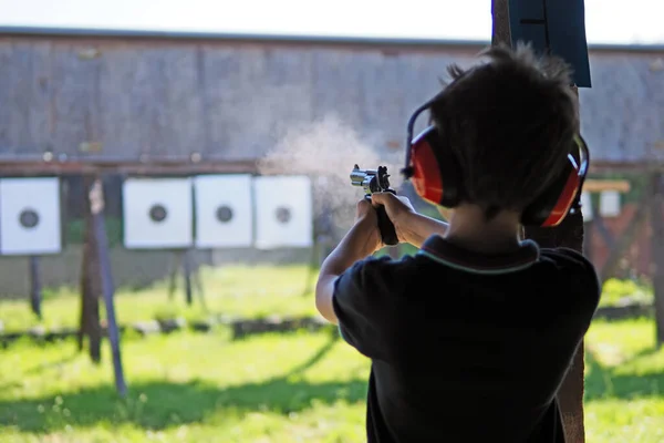 Fiatal Fiú Koncentrál Miközben Egy Revolverrel Lövöldözik Egy Lőtéren — Stock Fotó