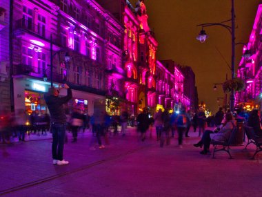 Caddenin mor renkleri. Lodz, Polonya - 08 Ekim 2016 Lodz 'daki Piotrkowska Caddesi' ndeki Aydınlık Sanat Festivali sırasında muhteşem ve renkli apartman evleri.