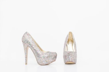 Parlak gümüş topuklu kadın ayakkabıları beyaz arka planda izole edilmiş.