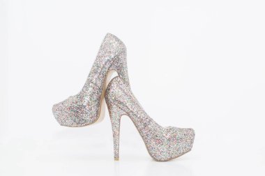 Parlak gümüş topuklu kadın ayakkabıları beyaz arka planda izole edilmiş.
