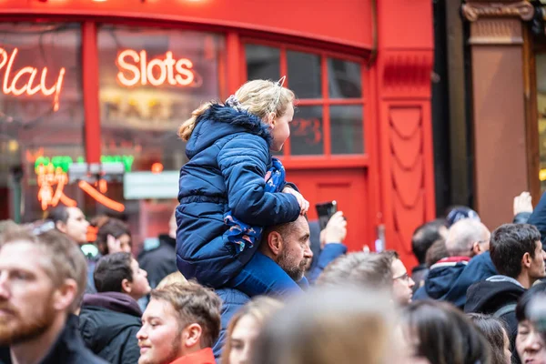 London den 26 januari 2020. En leende ung flicka som sitter på sina fäders axlar medan hon går genom en folkmassa i Chinatown. Nyårsfirande — Stockfoto