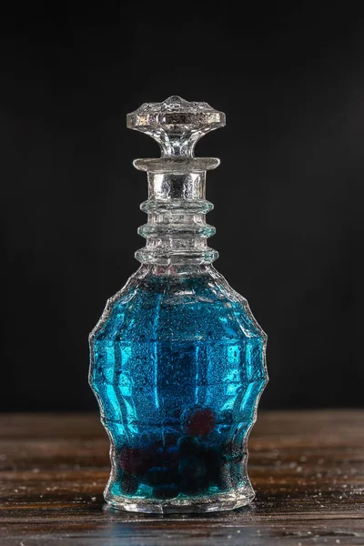 Mavi kokteyl, ahşap masada eski sürahide.