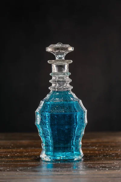 Blå cocktail i vintage decanter på trebord – stockfoto