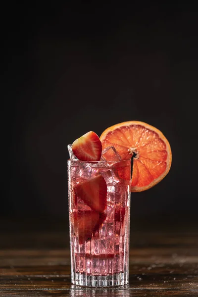 Różowy koktajl z lodem i truskawkami, ozdobiony plasterkiem grejpfruta — Zdjęcie stockowe