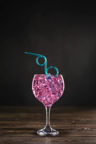 Стакан с розовым коктейлем, наполненный льдом на тёмном фоне — стоковое фото