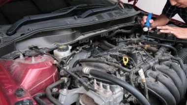 Asyalı Tamirci: Uyarıcı akıllı telefondan motora el feneri motoru kontrolü yap. Araba mühendisliği ile hizmet sigortası için kırmızı araba. Otomotiv tamir otomobili için kırmızı araba.