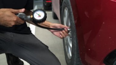 Asyalı adam arabası teftişi Ölçüm miktarı Şişmiş Lastik Lastikler