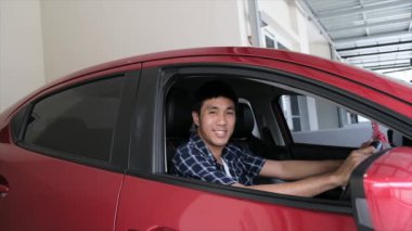 Asyalı adam otomotiv için anahtarsız kırmızı araba kapısını açıyor.